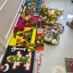The vibrant and detailed setup for a housewarming puja. The geometric patterns made from rice and pulses are traditional elements that invite prosperity and good fortune into the home.