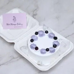 A classic blueberry bento cake. This small cake is perfect for an intimate celebration, topped with fresh blueberries and delicate purple frosting swirls.