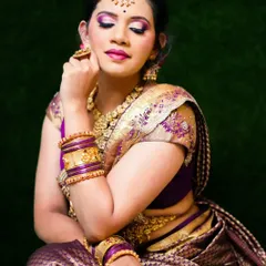 This South Indian bridal look features a vibrant purple eyeshadow that matches the saree's border. The skin is kept luminous with waterproof HD makeup, perfect for long hours and emotional moments.