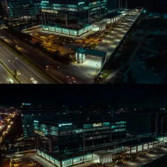 A dramatic night-time aerial shot of the Collins Aerospace building in Bengaluru. Our low-light drone photography highlights the building's modern design and illumination against the city skyline.