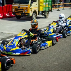 Our karts lined up and ready to roll out for a heat race. The distinctive blue and yellow livery of Kartkrew Motorsports stands out on the grid.