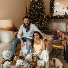 A lifestyle portrait of Sasha Grewal and her partner for Grazia India, seated in their living room by a Christmas tree.