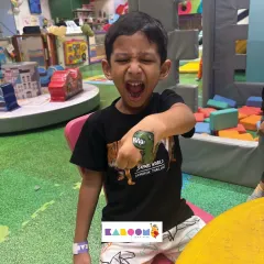 Roar! A young guest shows off his fierce dinosaur temporary tattoo. This is one of our most popular party activities, letting kids express themselves with safe, fun body art.