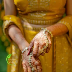A candid shot of the bride's hands, adorned with beautiful jewellery that complements her henna design.