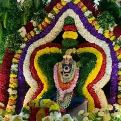 An incredibly detailed and colorful floral arrangement framing a deity, showcasing my expertise in creating large, multi-layered adornments.