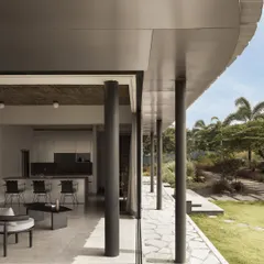 The deep, curved veranda of Pavilion House blurs the line between the living room and the garden. This architectural feature provides shade from the afternoon sun while framing uninterrupted views of the landscape, embodying our principle of indoor-outdoor living.
