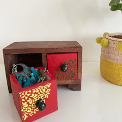 This hand-painted wooden jewelry box, with its bright red drawers and traditional patterns, is perfect for storing your favorite trinkets. Each one is painted with love and care.
