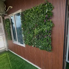 This project involved installing artificial grass and vertical green panels on a balcony with wood-paneled walls. The combination of textures creates a modern and warm aesthetic.