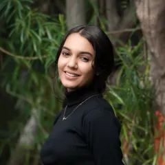 Shot against a natural, leafy background, this portrait has a fresh and organic feel. The model's direct, smiling gaze connects with the viewer, creating a trustworthy and confident personal branding image.