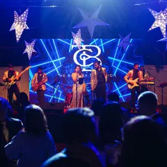 On stage for a Christmas Eve performance. The stage was decked out with stars and a custom LED backdrop featuring our logo, creating a festive and professional look.