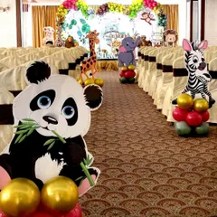 I make sure the theme extends beyond the main stage. Here, the party entrance aisle is lined with large cutouts of jungle animals like a panda, zebra, and giraffe, each with a small balloon cluster to welcome guests into the wild.