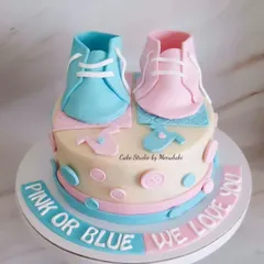 A 'Pink or Blue, We Love You' baby shower cake. This design features adorable, handcrafted baby booties in both pink and blue.