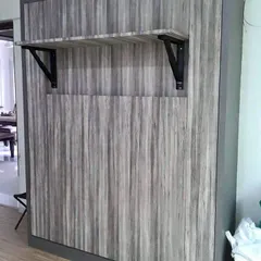 The same wall-mounted bed, featuring a convenient fold-out shelf. This small addition can serve as a nightstand or a small desk, adding another layer of functionality to the design.