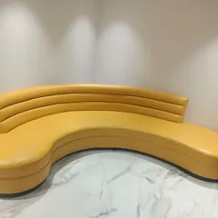 A custom-designed curved sofa in a bright yellow. I love creating unique furniture pieces like this that not only provide seating but also act as a piece of art in the room.