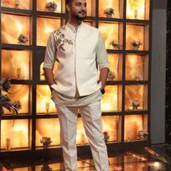 A client looking sharp in our off-white Indo-Western set. The ensemble includes a kurta, trousers, and a matching Nehru jacket with delicate floral embroidery on the shoulder.