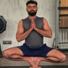 In Malasana, or Garland Pose, with hands in Anjali Mudra. This posture is not only a deep hip opener but also a grounding position for meditation, helping to improve focus and reduce stress.