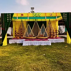 For traditional pre-wedding functions, I design vibrant and beautiful setups like this Haldi ceremony stage. This outdoor mandap uses a classic yellow and green color scheme with marigold flowers and traditional seating for the bride and groom.