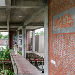 A large terracotta jali wall with an intricate leaf pattern at the entrance of the ASA office. This functional screen provides ventilation and privacy while serving as a beautiful piece of architectural art.