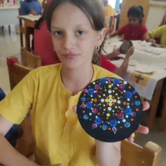 A student at the Waldorf school proudly displays the intricate dot art coaster she made during my workshop. Bringing art directly into schools is a wonderful way to foster creativity.