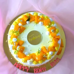 A fresh mango birthday cake, decorated with a ring of mango chunks and edible silver leaf. A simple, delicious way to celebrate.