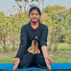 The Kandpīḍāsana, a challenging pose that requires flexibility in the hips and spine. This young yogini holds it with a calm and steady gaze.