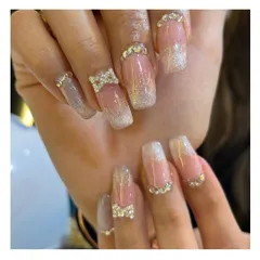 Go all out with this glamorous set. It features a glitter ombre effect on square-shaped nails, adorned with rhinestone-encrusted 3D bows and additional crystals at the cuticle for maximum sparkle.