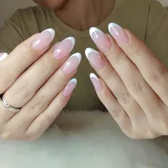 A classic French manicure on elegant, oval-shaped extensions. The clean white tips and natural pink base create a timeless and polished look that's perfect for any occasion.