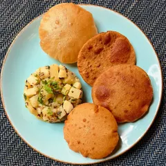Our delicious Farali Puri Bhaji is a perfect blend of tradition and taste for the Shravan season. This plate features a variety of puris served with our special potato bhaji.
