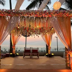 This is one of our favorite mandap designs, set against the beautiful Mumbai sunset. The structure is adorned with dense floral arrangements and hanging blooms, creating a rich and luxurious focal point for the wedding ceremony.