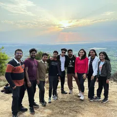 The same happy group at the Skandgiri summit, capturing the golden hour light.