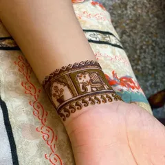 A simple yet elegant wrist cuff design. This pattern includes a small elephant and a floral motif, perfect for a minimalist festive look.