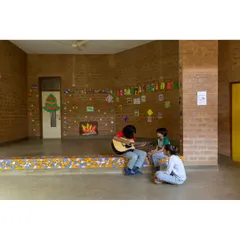 Students find a space for creative expression on the mosaic-tiled stage at Buddhi School in Bengaluru. We design learning environments to be joyful and interactive, using warm, natural materials like earth blocks to create inviting spaces for children.