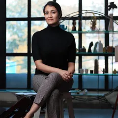 A seated portrait in a professional setting. The large window provides beautiful natural light, creating a soft yet defined look.