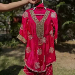 A close-up of my fuchsia Gota Patti sharara set. The detailed gold work on the neckline and the traditional motifs on the fabric showcase the craftsmanship I pour into every design.