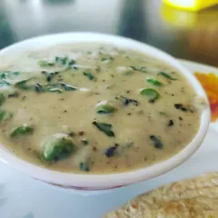 A close-up of our rich and creamy Methi Mutter Malai, a flavorful curry made with fenugreek leaves, green peas, and cream.