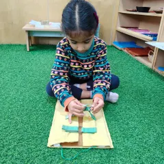 This child is mastering the skill of tying a bow using one of our dressing frames. These frames isolate specific skills, allowing children to practice and perfect them without frustration.