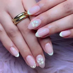 A soft and delicate floral French manicure. The classic design is elevated with a 3D white flower on the ring finger, complete with a tiny rhinestone center.
