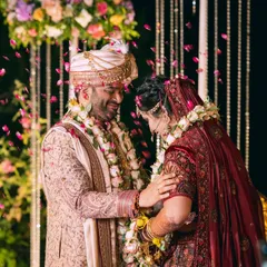 A candid moment of pure happiness and affection between the couple during their varmala ceremony, with a shower of rose petals.