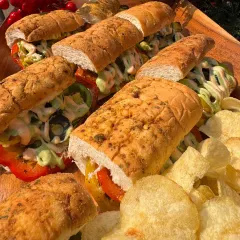 A platter of hearty sandwiches served with potato chips, perfect for a casual corporate lunch or daytime event.