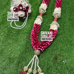 This wedding set includes a beautiful varmala made from red rose petals and white flowers, accented with golden beads. It comes with a matching hand bouquet for the groom, creating a perfectly coordinated look.