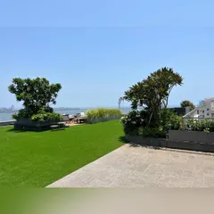 We transform apartment rooftops into exclusive retreats. This terrace garden offers a lush lawn and curated planters, creating a serene escape with an uninterrupted view of the Mumbai skyline and the sea beyond.