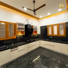A spacious U-shaped kitchen featuring white cabinets, a black granite countertop, and a black chimney. The wooden-framed windows and upper cabinets add a touch of traditional warmth to the modern design.