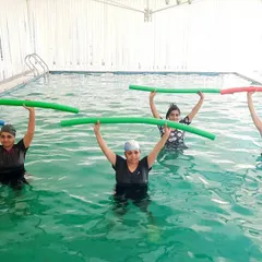We use a variety of equipment, like these pool noodles, for resistance training. This coordinated group exercise targets the upper body and core, making fitness feel like a team activity.