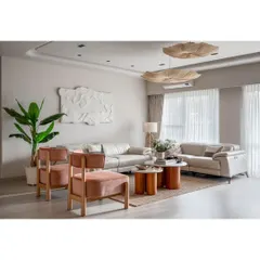 A full view of the living area, showing how we used curved lines in the ceiling and furniture to soften the space. The large windows and sheer curtains fill the room with beautiful, natural light.