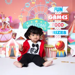 A full view of the exciting carnival theme. This setup is packed with details like a ticket booth, circus tent, and prizes, perfect for a milestone photoshoot.
