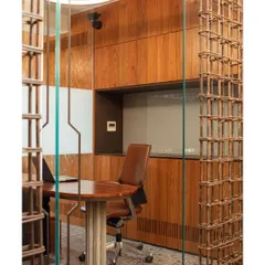 A closer look at the rebar screen partition, showing how the grid-like structure filters light and views while maintaining a sense of openness in the conference room.