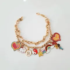A vibrant, fully loaded custom charm bracelet I made for a client. It features a mix of colorful hearts, a happy elephant, a yin-yang symbol, a rainbow, and the initial 'R' to make it extra personal.