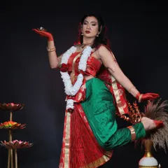 A full-length shot from the goddess shoot, showcasing the traditional Bengali-style saree drape and the powerful yet graceful pose. The makeup is central to creating this divine character.
