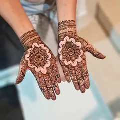 A beautiful mandala design with a floral center and intricate patterns filling the rest of the hands.