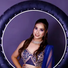 A modern studio portrait showcasing our use of professional lighting. The model, framed by a ring light, is wearing an intricate blue lehenga, highlighting our ability to create crisp, contemporary beauty shots for model portfolios.